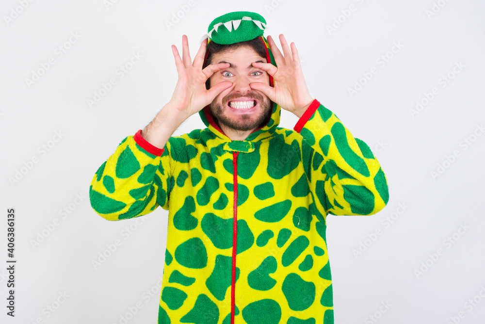 Young caucasian man wearing a pajama standing against white background keeping eyes opened to find a success opportunity. Young caucasian man wearing a pajama standing against white background keeping eyes opened to find a success opportunity.