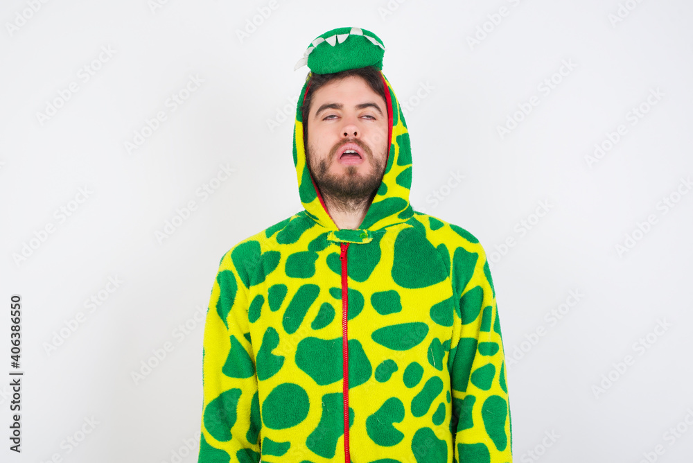 Fototapeta premium Young caucasian man wearing a pajama standing against white background looking sleepy and tired, exhausted for fatigue and hangover, lazy eyes in the morning.