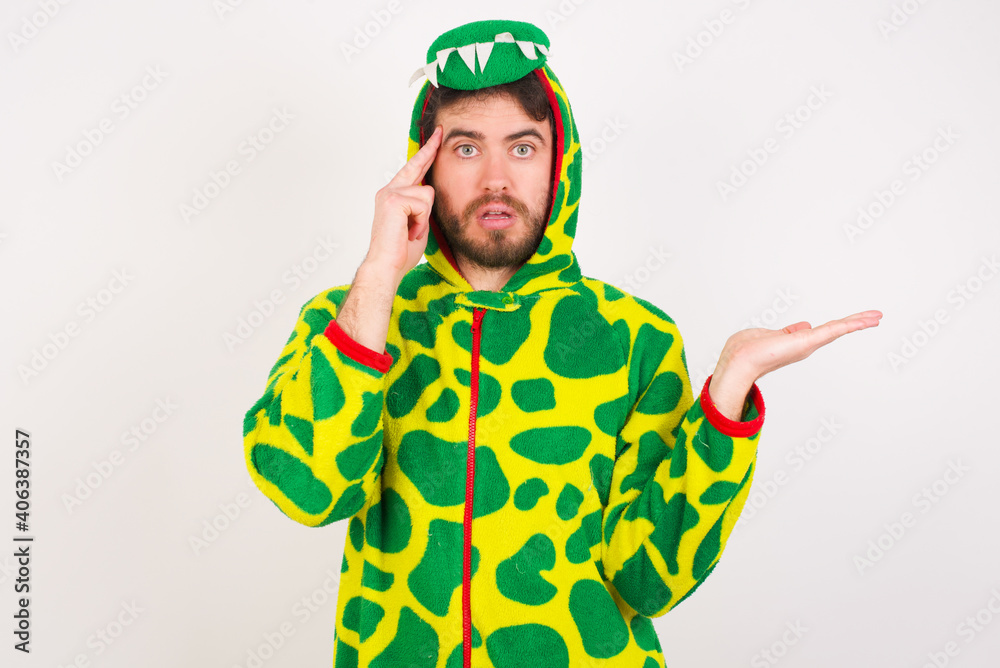 Fototapeta premium Young caucasian man wearing a pajama standing against white background confused and annoyed with open palm showing copy space and pointing finger to forehead. Think about it.