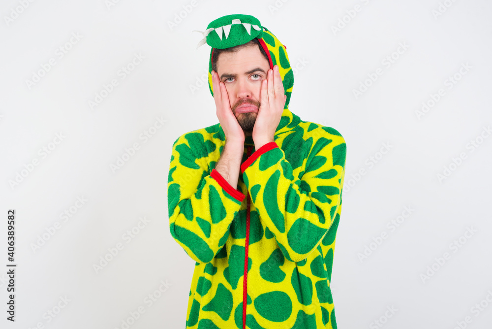 Fototapeta premium Young caucasian man wearing a pajama standing against white background Tired hands covering face, depression and sadness, upset and irritated for problem