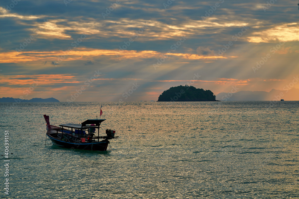 Sunrise skyline with sun rays through from cloud in twilight time with fisherman boat in sea