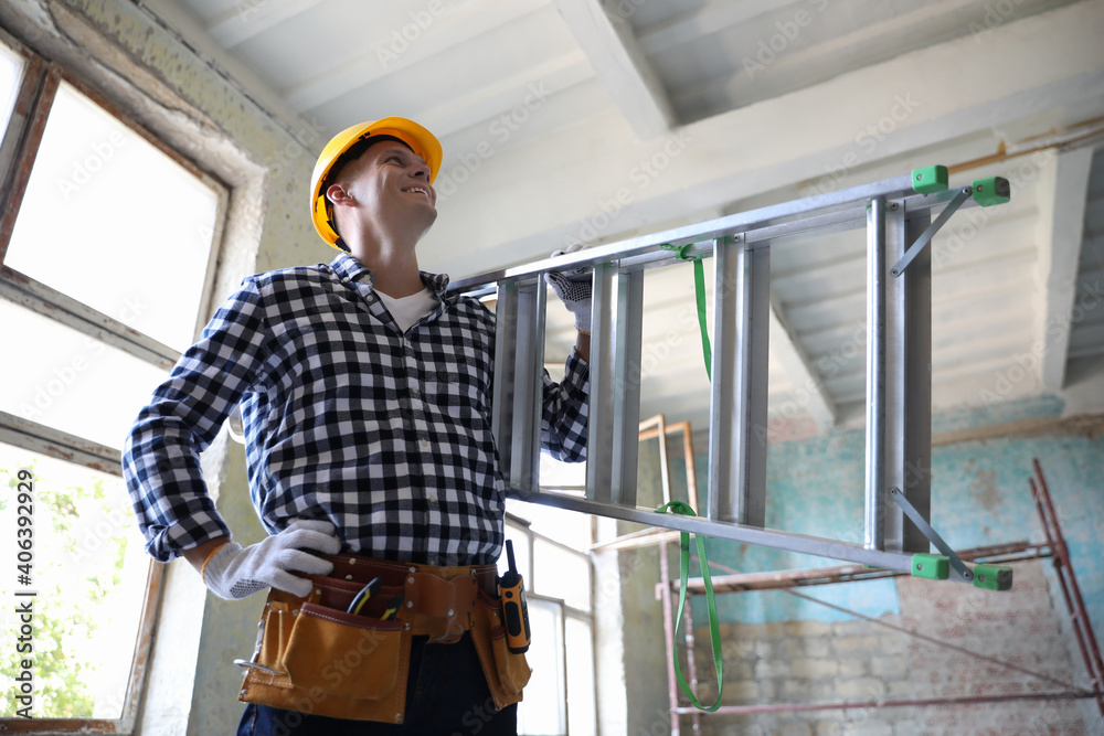 Professional constructor with ladder in old building