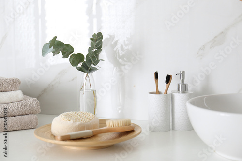 Fresh eucalyptus branches and bathroom items on countertop