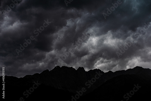 Dunkle Kulisse mit Wolken und Bergen als Silhouette