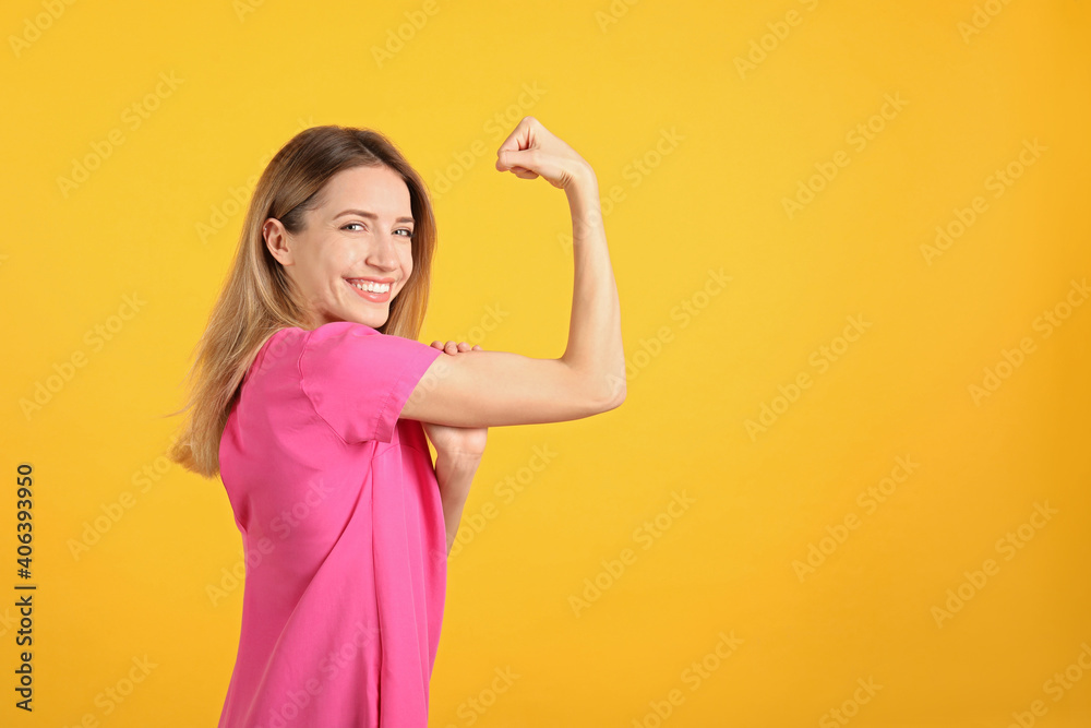Strong woman as symbol of girl power on yellow background, space for text. 8 March concept Strong woman as symbol of girl power on yellow background, space for text. 8 March concept