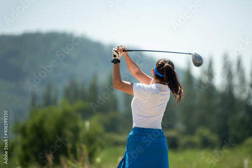Golfer sport course golf ball fairway. People lifestyle woman playing game golf and hitting go on green grass river and mountain background. Asia female player game shot in summer