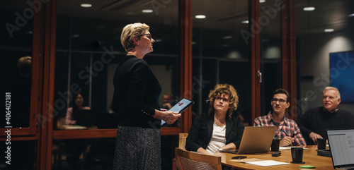 Businesswoman addressing team in office boardroom