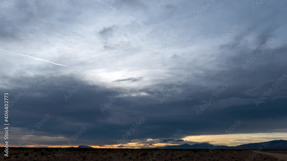 Clouds cross the sky as the sun sets beyond the distant mountains in the Mojave Desert - wide angle static time lapse Clouds cross the sky as the sun sets beyond the distant mountains in the Mojave Desert - wide angle static time lapse
