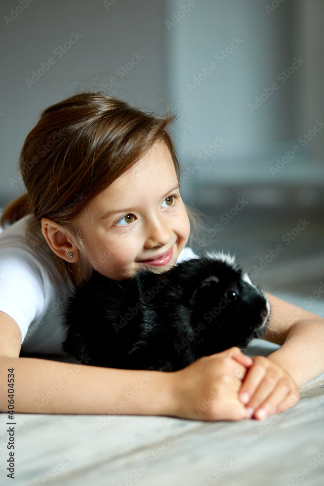 Portrait of happy smiling little girl hugging black guinea pig. Portrait of happy smiling little girl hugging black guinea pig.