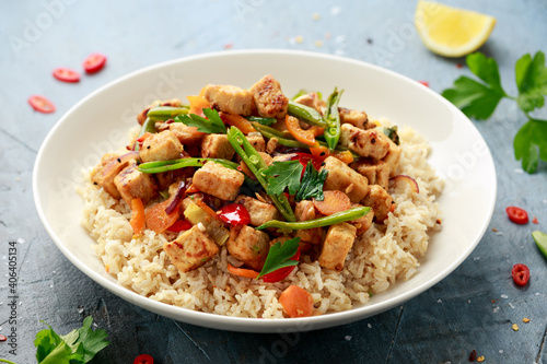 Vegetarian meat free mycoprotein pieces vegetable stir fry, brown rice served in white plate