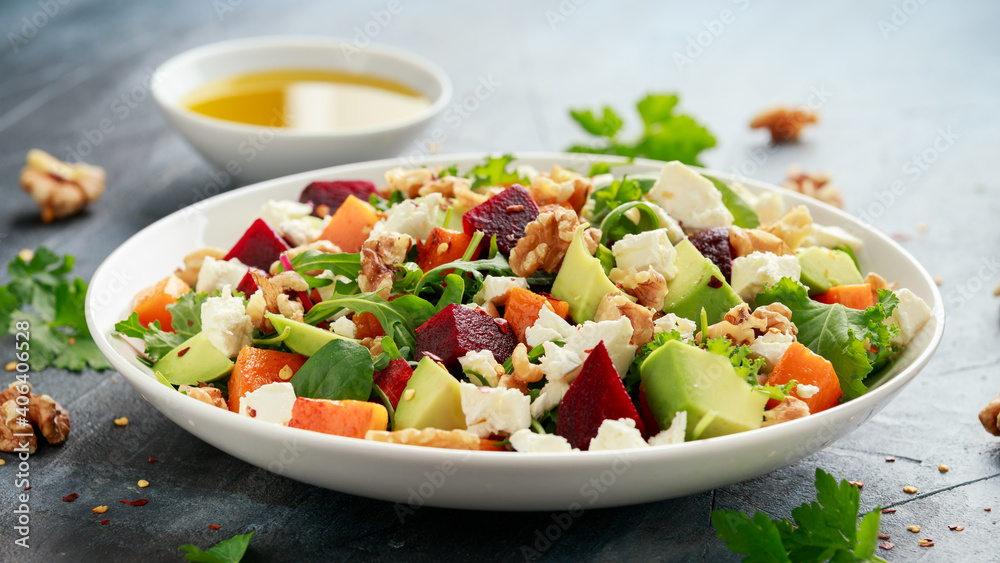Healthy Butternut squash salad with beetroot, avocado, walnut and feta cheese in white bowl Healthy Butternut squash salad with beetroot, avocado, walnut and feta cheese in white bowl