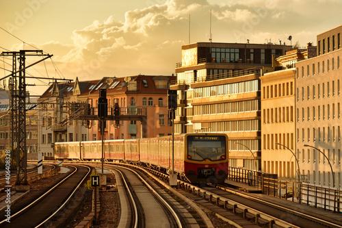 S-Bahn train moving away on the railroad in Berlin during sunset