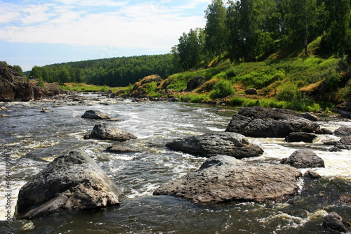A fast mountain river flows between green banks