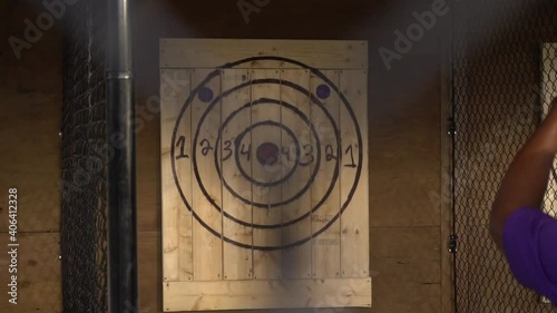 Axe throwing target cages with two people throwing axes in slow motion