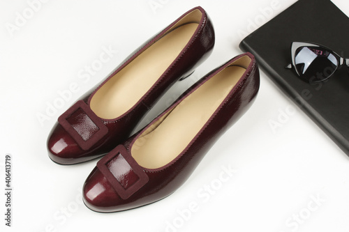 Cherry pumps with heels. The accessories of notebook and glasses.