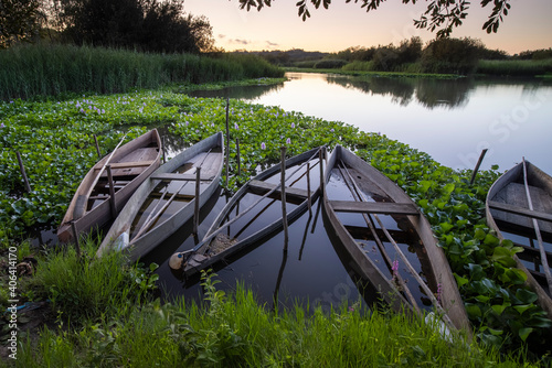 a group of wooden boats at sunset in lagoon photo