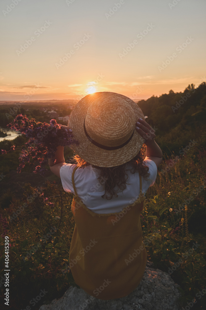 young girl in straw hat enjoy the sunset