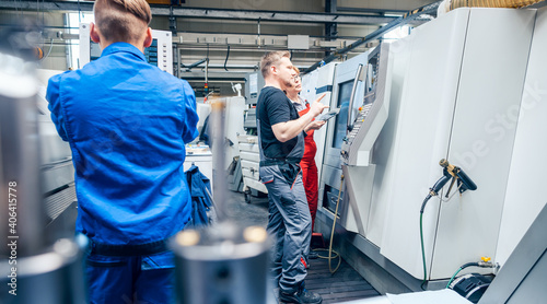 Foto Factory floor with workers at lathe machine