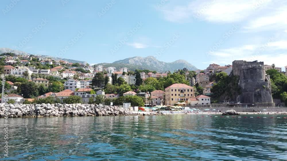 Sea fortress of Herceg Novi, Montenegro with mountains in the background - Steadicam shot from the water
