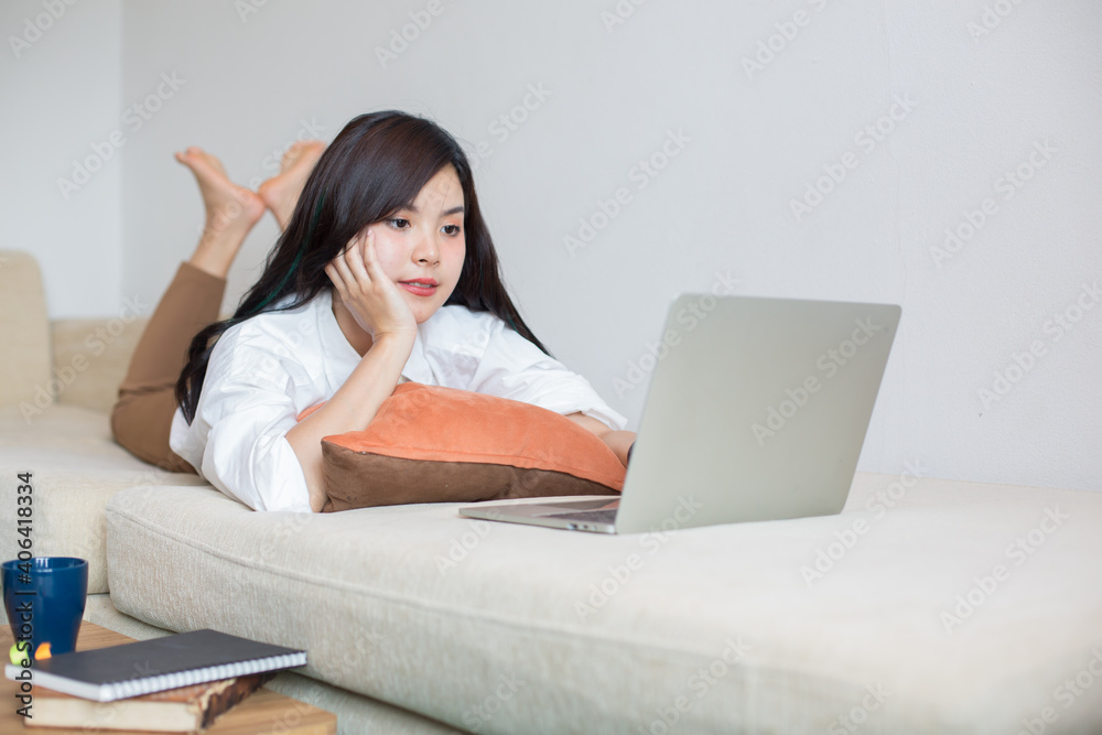 Asian women are using computers to work at home. According to the government's policy of working at home Caused by the Covid virus Asian women are using computers to work at home. According to the government's policy of working at home Caused by the Covid virus