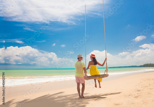 Couple in love on a swing by the sea. Couple in love on an island off the coast. Honeymoon.