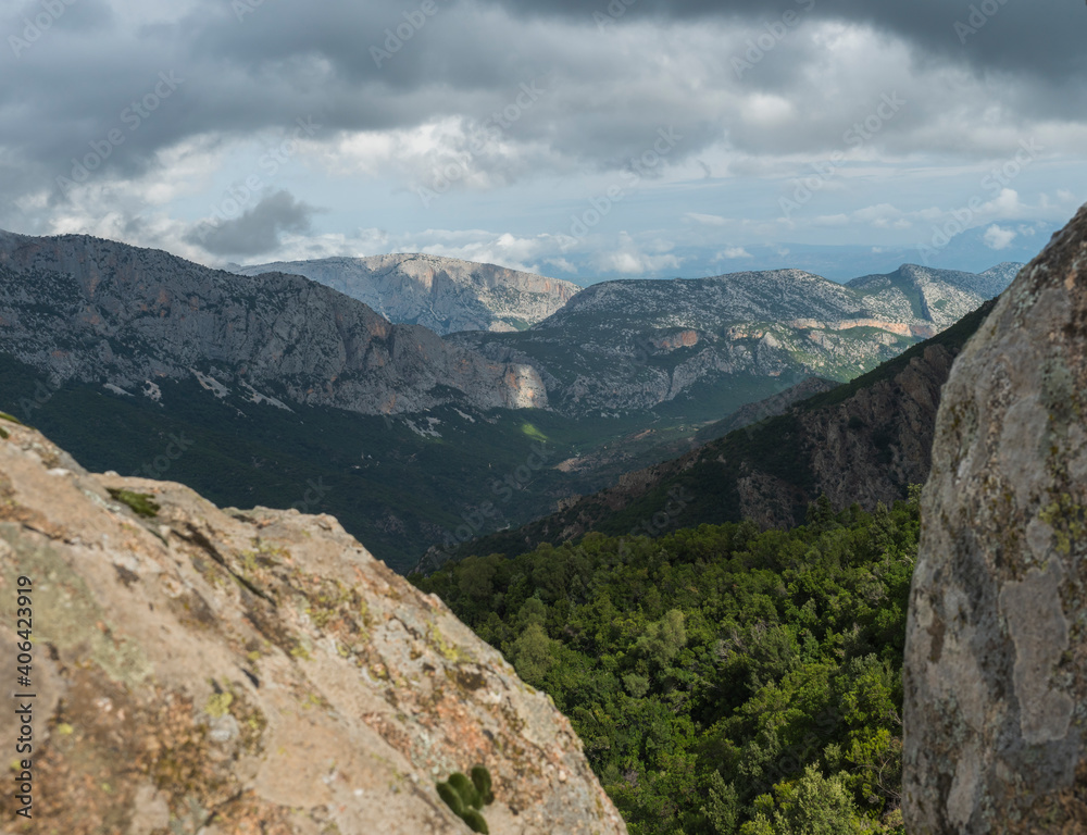 View of Gola Su Gorropu gorge, famous hiking destinantion at green forest landscape of Supramonte Mountains with limestone rock and mediterranean vegetation, Nuoro, Sardinia, Italy. Summer cloudy day