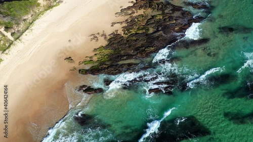 Rising cinematic drone shot of Shelly Beach and the Wellington Rocks with coastal highway and ocean waves at Nambucca Heads New South Wales Australia photo