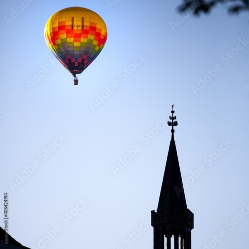 colorful hot air balloon floating over cathedral rooftop