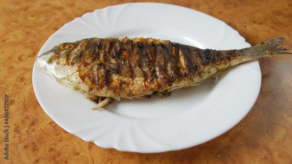 Fried fish on white plate grilled Dorado push out backward camera movement Fried fish on white plate grilled Dorado push out backward camera movement
