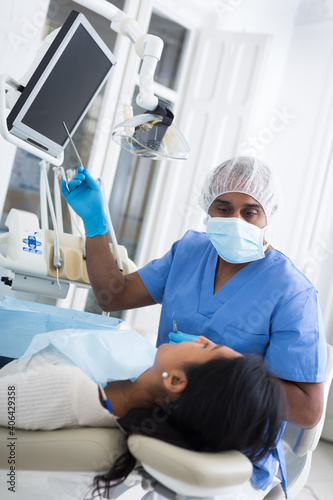 Doctor man dentist shows patient an x-ray