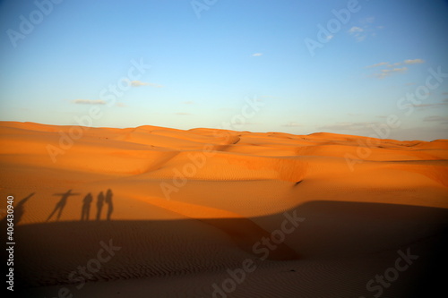 Shadows of people projected on the dunes by the light of the sunset, Wahiba Sands / Sharqiya Sands, Oman