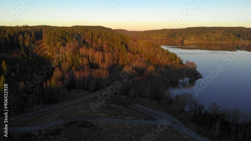 Majestic aerial view of scandiavian forest landscape outdoors at sunset. Drone flying above peaceful lake, Sweden, dolly in photo