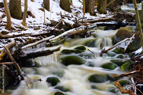 Fast flowing brook in winter forest