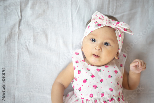 4 Month Old Baby Girl Laying On her Back Looking Up with multiple expressions