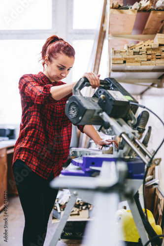 Woman manual worker operating tools in workshop