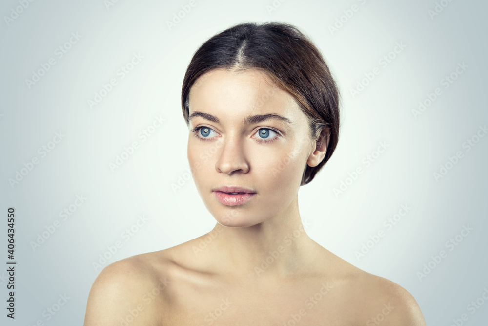 Young beautiful woman with bare shoulders, beauty portrait on a light background Young beautiful woman with bare shoulders, beauty portrait on a light background