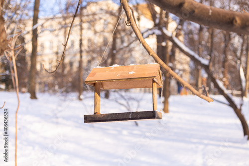 Birdhouse in winter snowy park forest