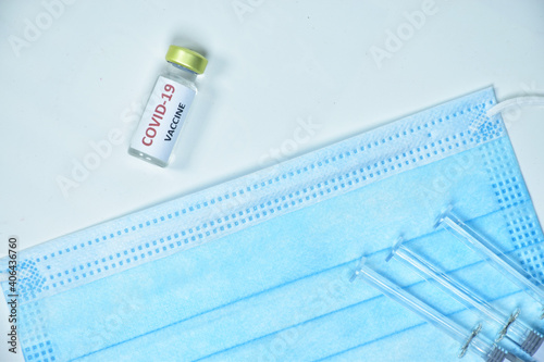 A bottle of the COVID-19 vaccine is placed on a mask.