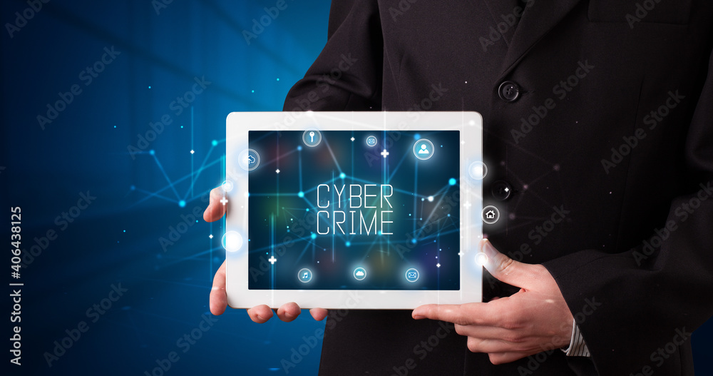 Young business person working on tablet and shows the digital sign: CYBER CRIME Young business person working on tablet and shows the digital sign: CYBER CRIME