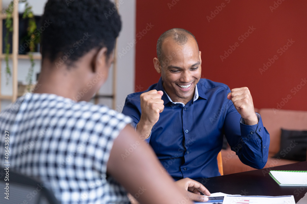 Diverse business people sitting going through paperwork in a modern office Diverse business people sitting going through paperwork in a modern office