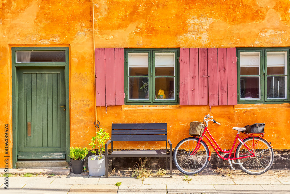 Old yellow house of Nyboder district with a red bicycle. Old Medieval district in Copenhagen, Denmark