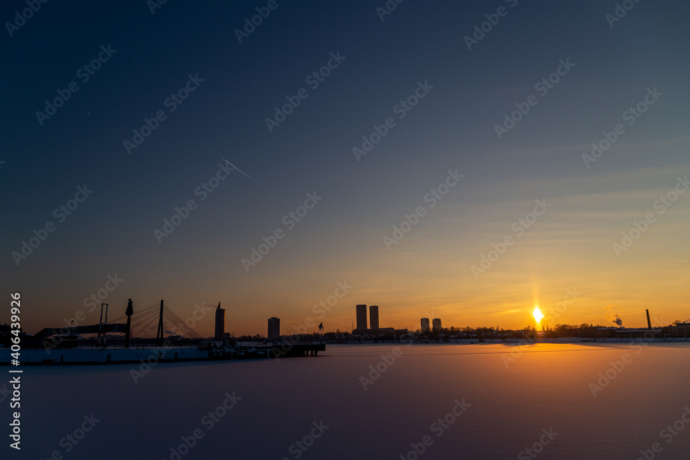 Sunset over the river on a cold winter day with the city in the background.