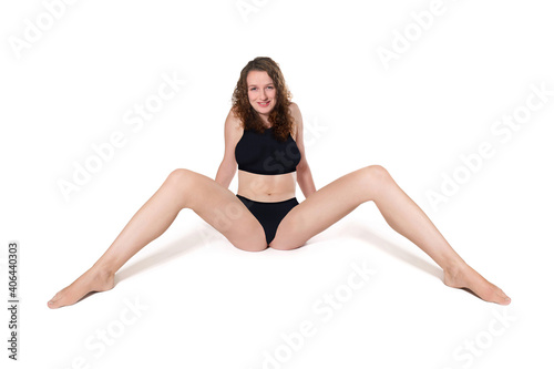 Smiling woman wearing a black bikini in front of white studio background