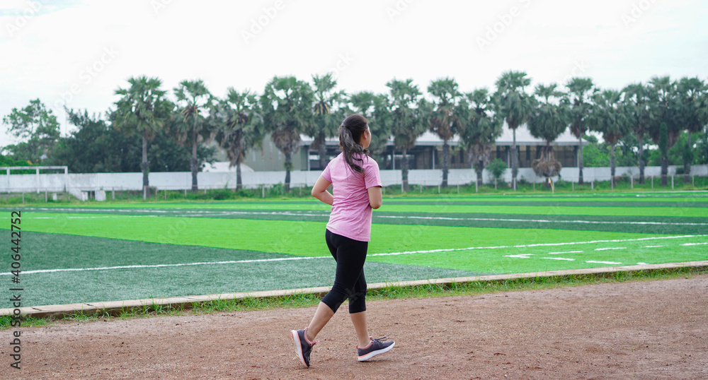asian woman athlete running on track. back view