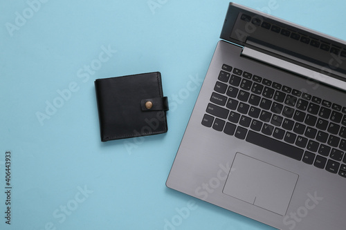 Laptop and Leather wallet on blue background. Online payments