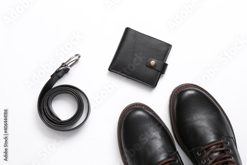 Men's accessories on white background. Leather boots, wallet and belt. Top view. Flat lay