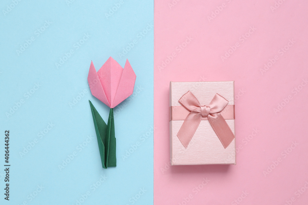 Handmade origami tulip and gift boxes on pink blue background. 8 March, women's day or birthday concept. Top view. Minimalism Handmade origami tulip and gift boxes on pink blue background. 8 March, women's day or birthday concept. Top view. Minimalism