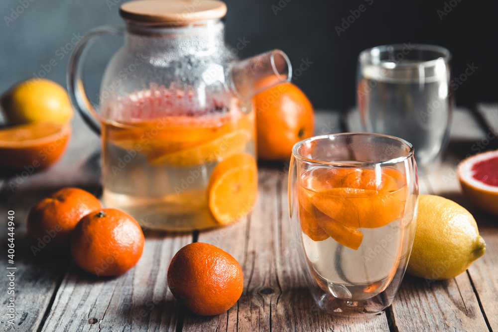 Citrus tea in a transparent teapot on a table with grapefruit and on a wooden table. Healthy drink. Citrus tea in a transparent teapot on a table with grapefruit and on a wooden table. Healthy drink.