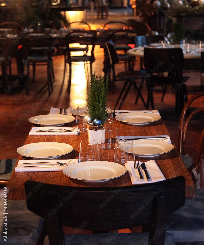 Christmas table in the cafe, white plates, wooden chairs. Christmas table in the cafe, white plates, wooden chairs.