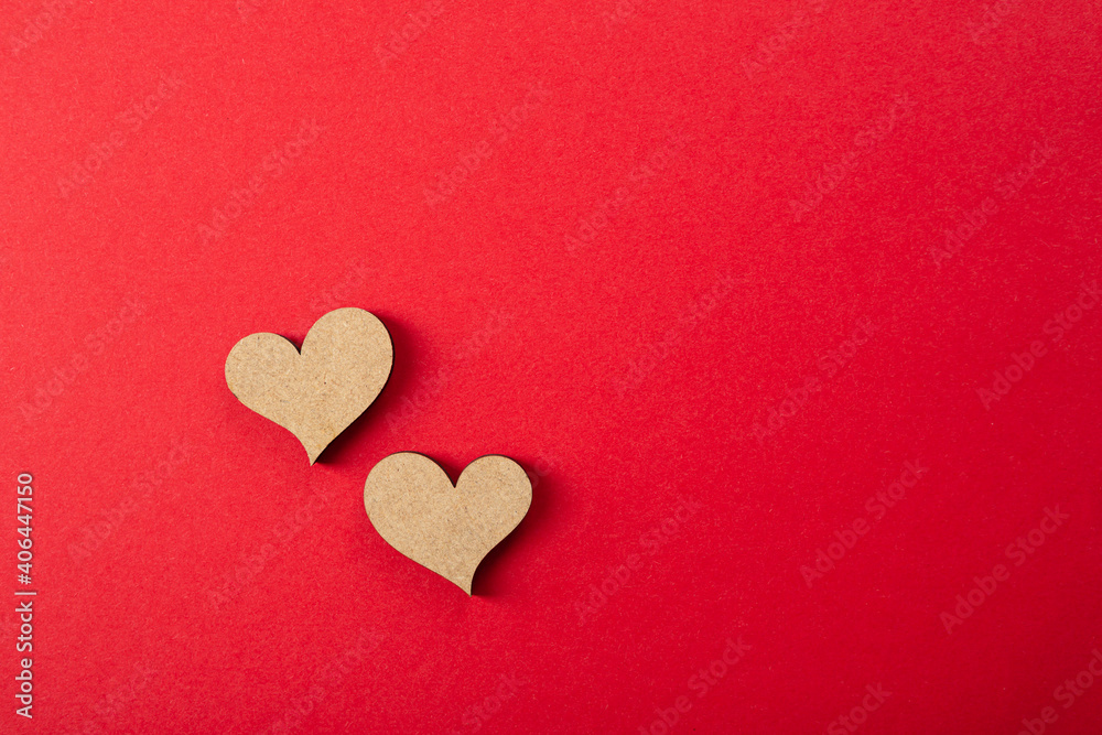 Two wooden heart on red surface, flat lay